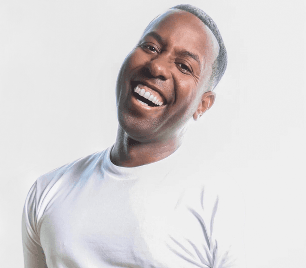 Celebrity stylist Johnny Wright, Glamsquad textured hair advisor, laughing in a white T-shirt